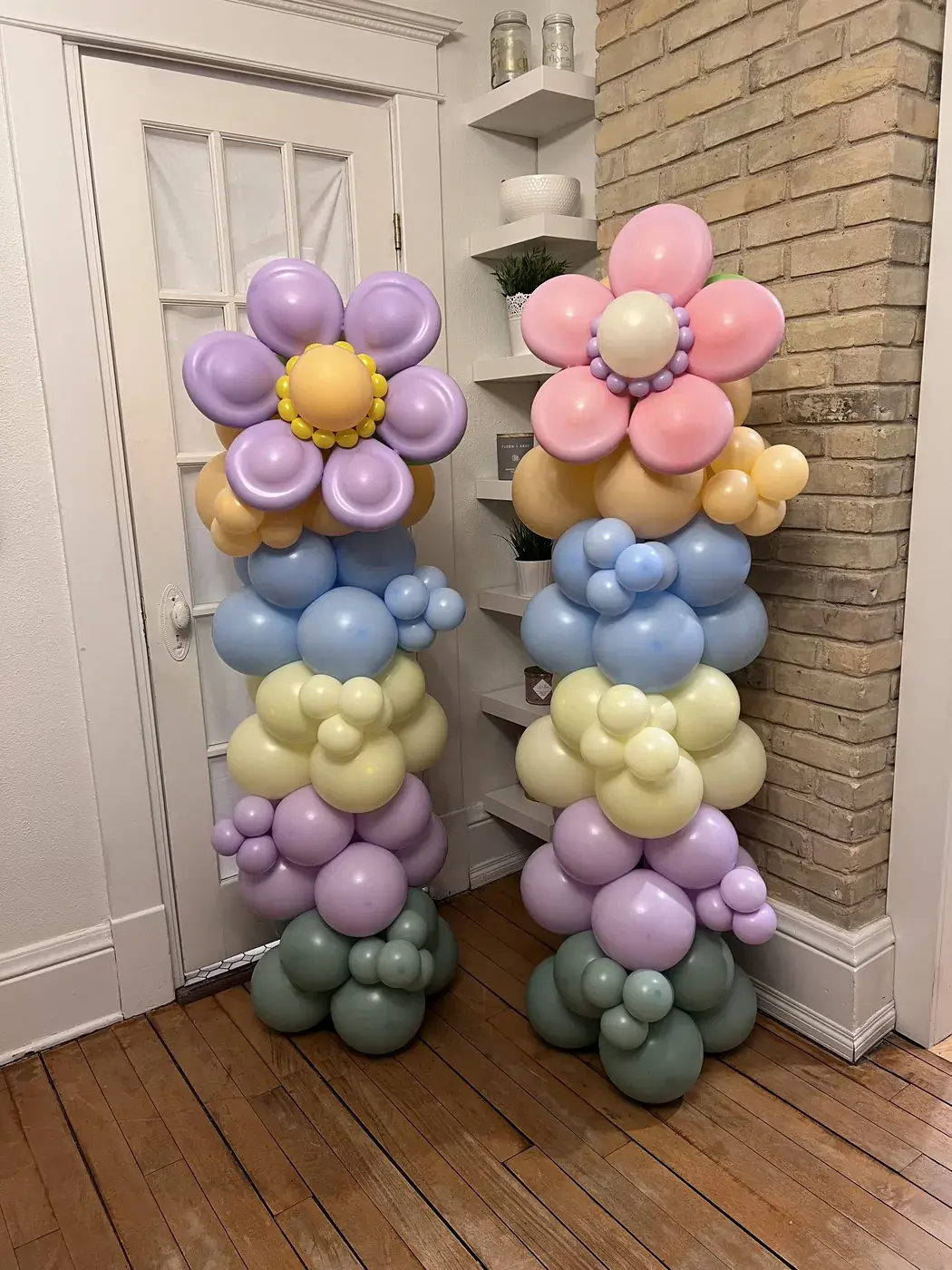 A pair of pastel balloon columns topped with hand twisted balloon daisies