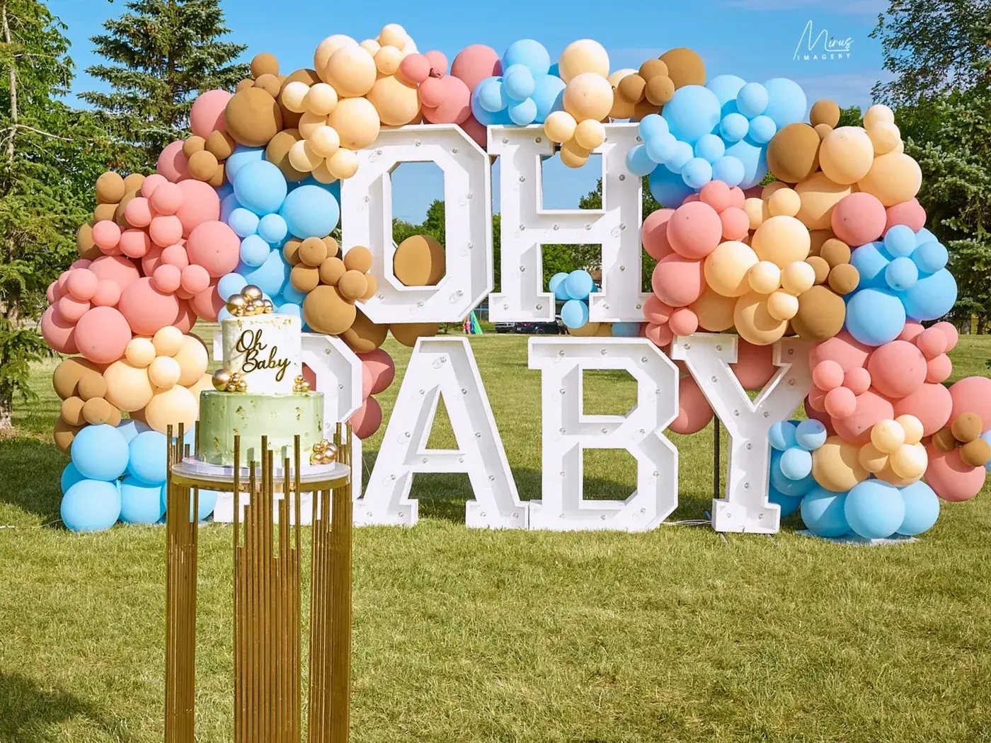 OH BABY marquee letters outdoors with a peach, sky and sage garland