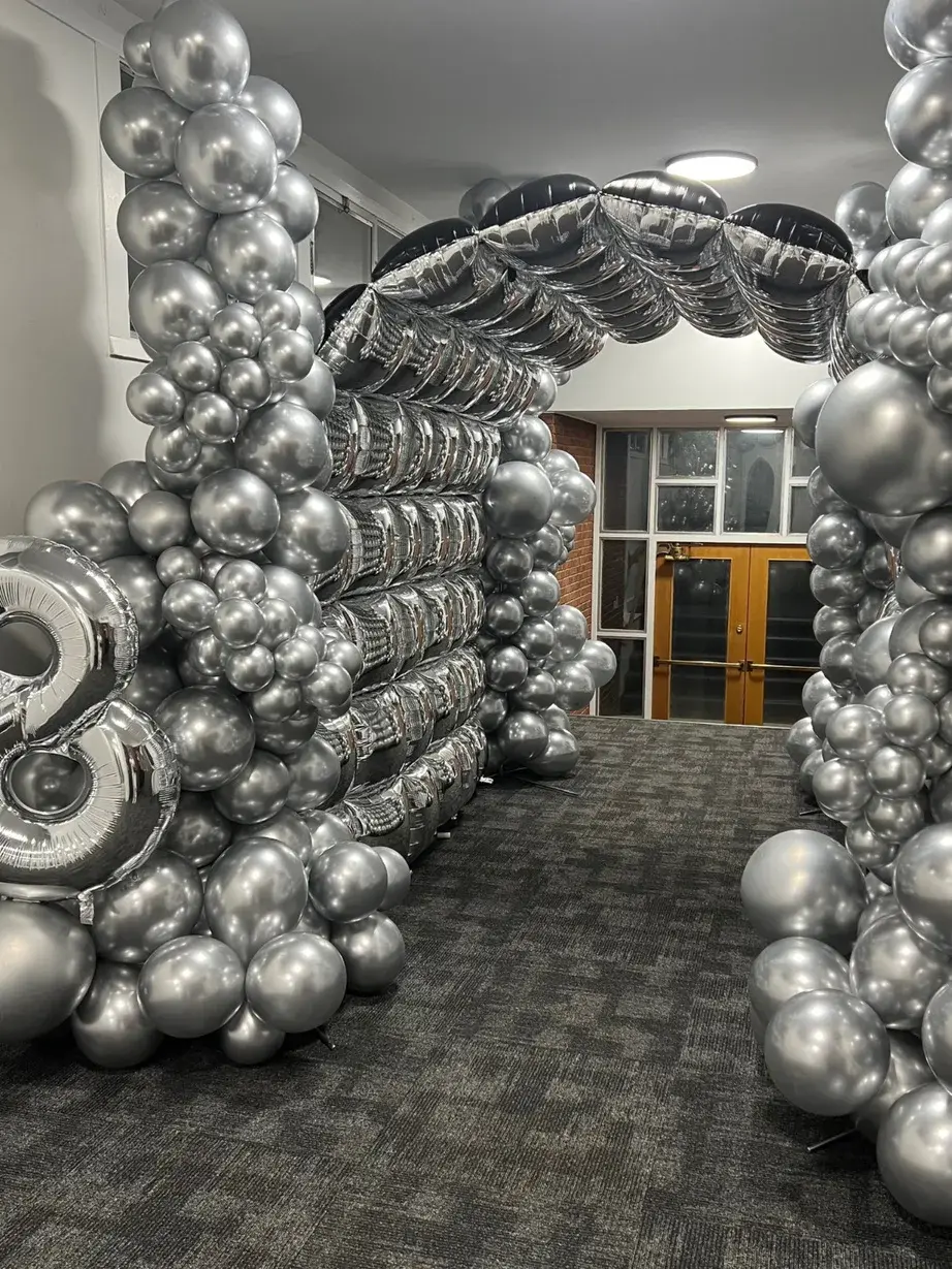 Silver chrome balloon tunnel running the length of an office hallway