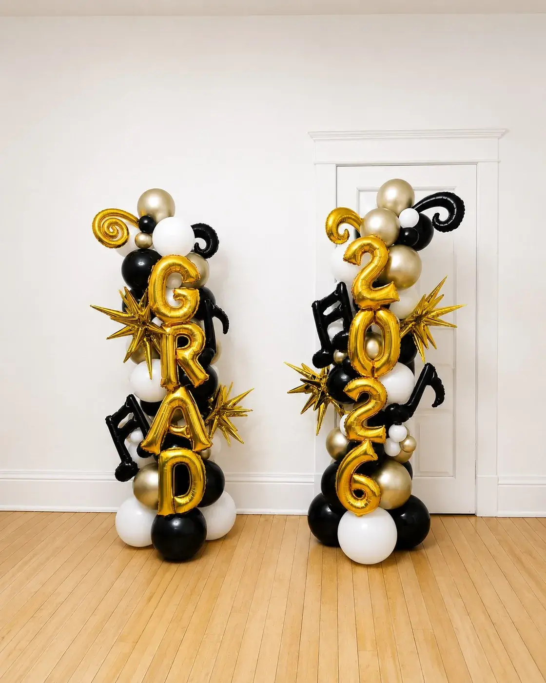 Black and gold GRAD and 2026 balloon columns in a hallway