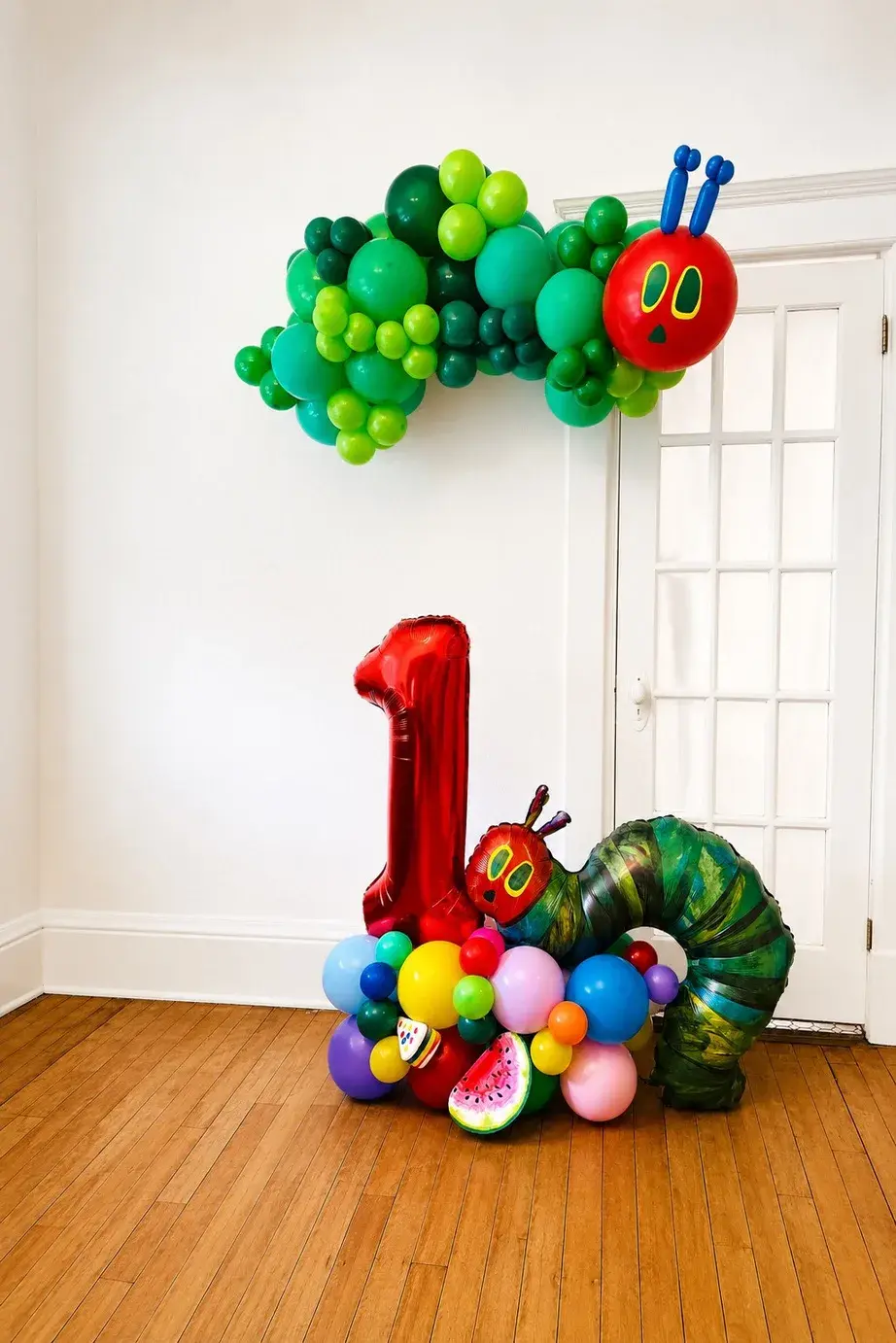 Hungry Caterpillar first birthday display with a red number one and fruit balloons
