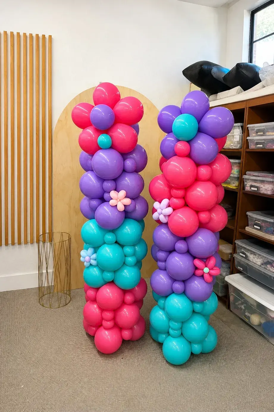 Pink, purple and teal balloon columns finished with twisted balloon flowers