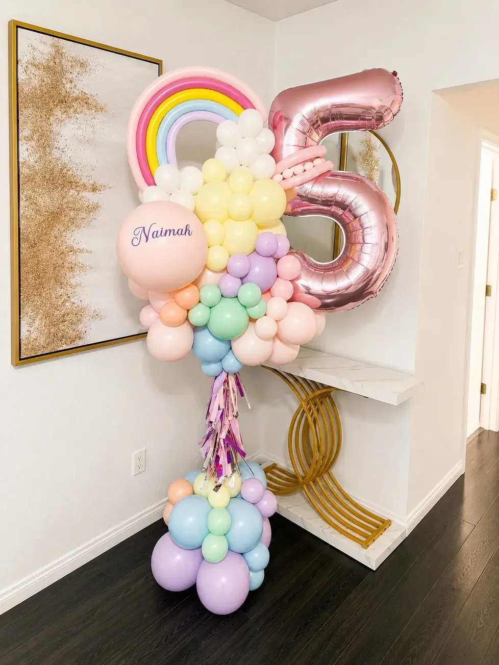 Rose gold number five with a pastel rainbow cluster and a personalised name balloon