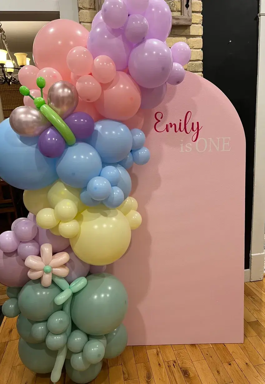 Pastel arch dressed with hand twisted balloon flowers for a first birthday